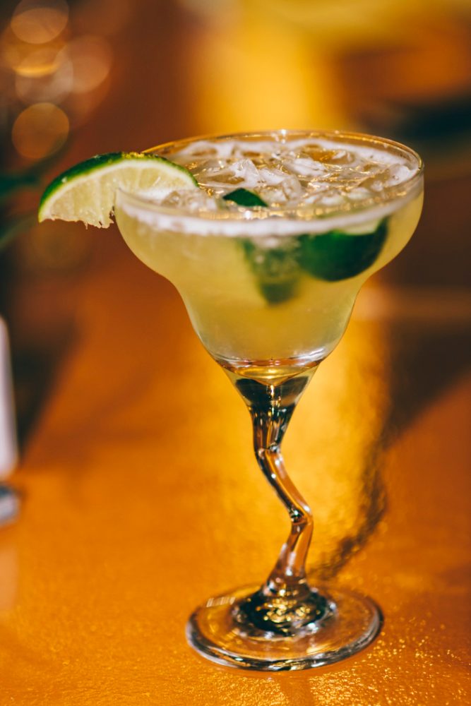 A margarita on the rocks with a salted rim and lime